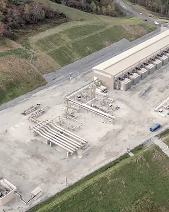 A compressor station among green hills, seen from the air